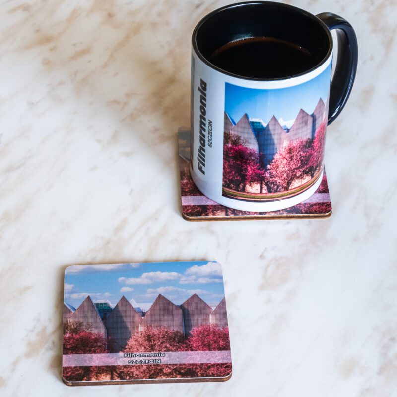 Ceramiczny kubek i drewniana podkładka z motywem szczecińskiej filharmonii.