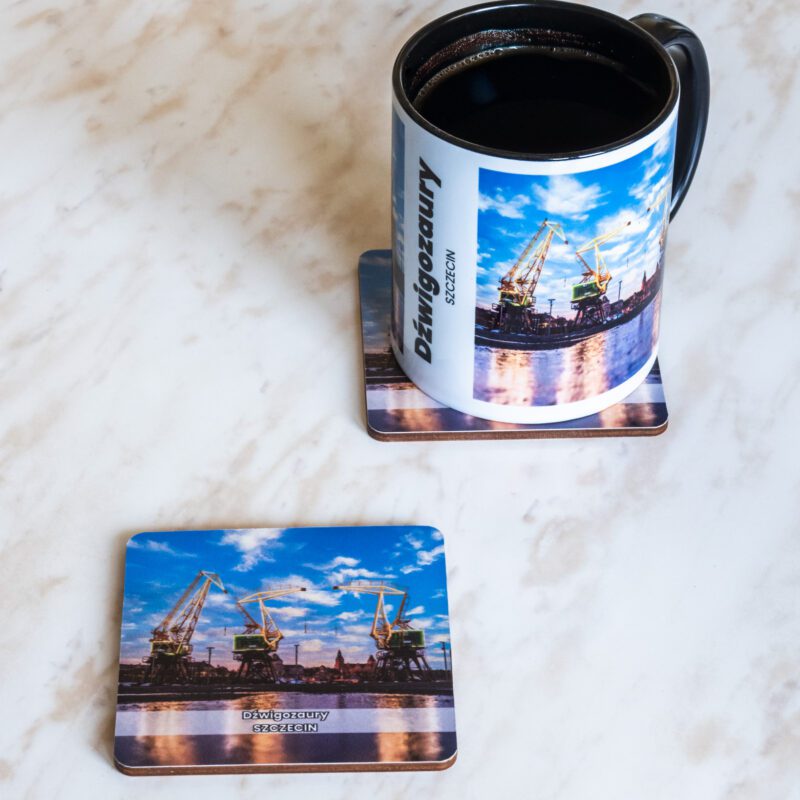 Ceramiczny kubek i drewniana podkładka z motywem szczecińskich dźwigozaurów.