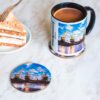 Ceramiczny kubek i drewniana podkładka z motywem szczecińskich dźwigozaurów.