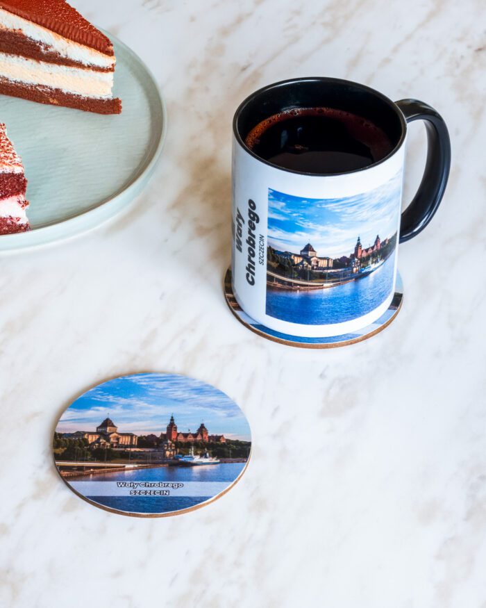 Ceramiczny kubek i drewniana podkładka z motywem Wałów Chrobrego w Szczecinie.