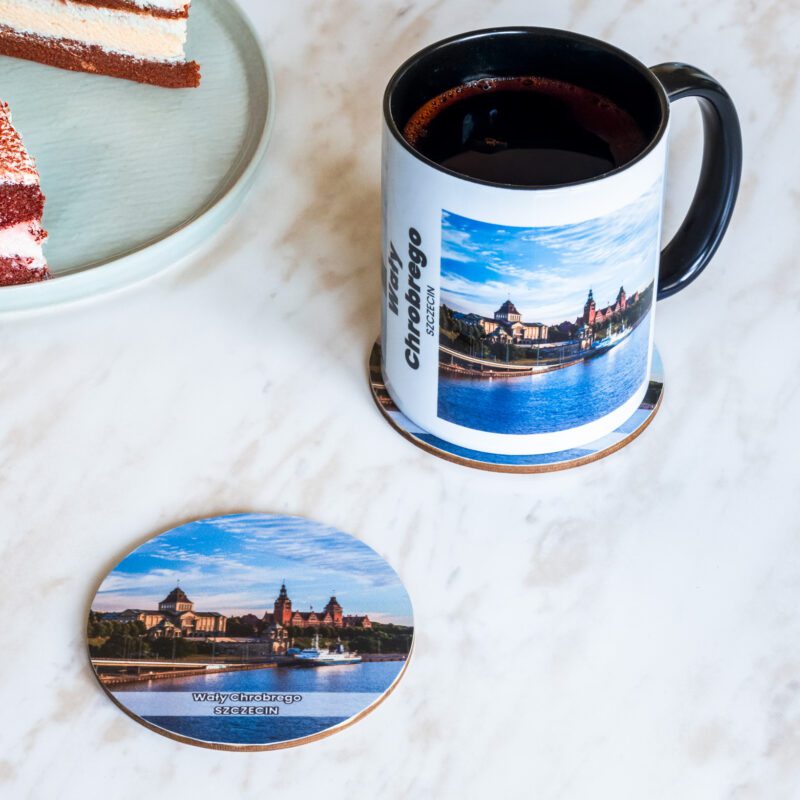 Ceramiczny kubek i drewniana podkładka z motywem Wałów Chrobrego w Szczecinie.