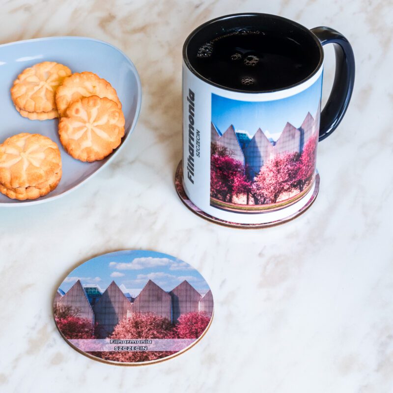 Ceramiczny kubek i drewniana podkładka z motywem szczecińskiej filharmonii.